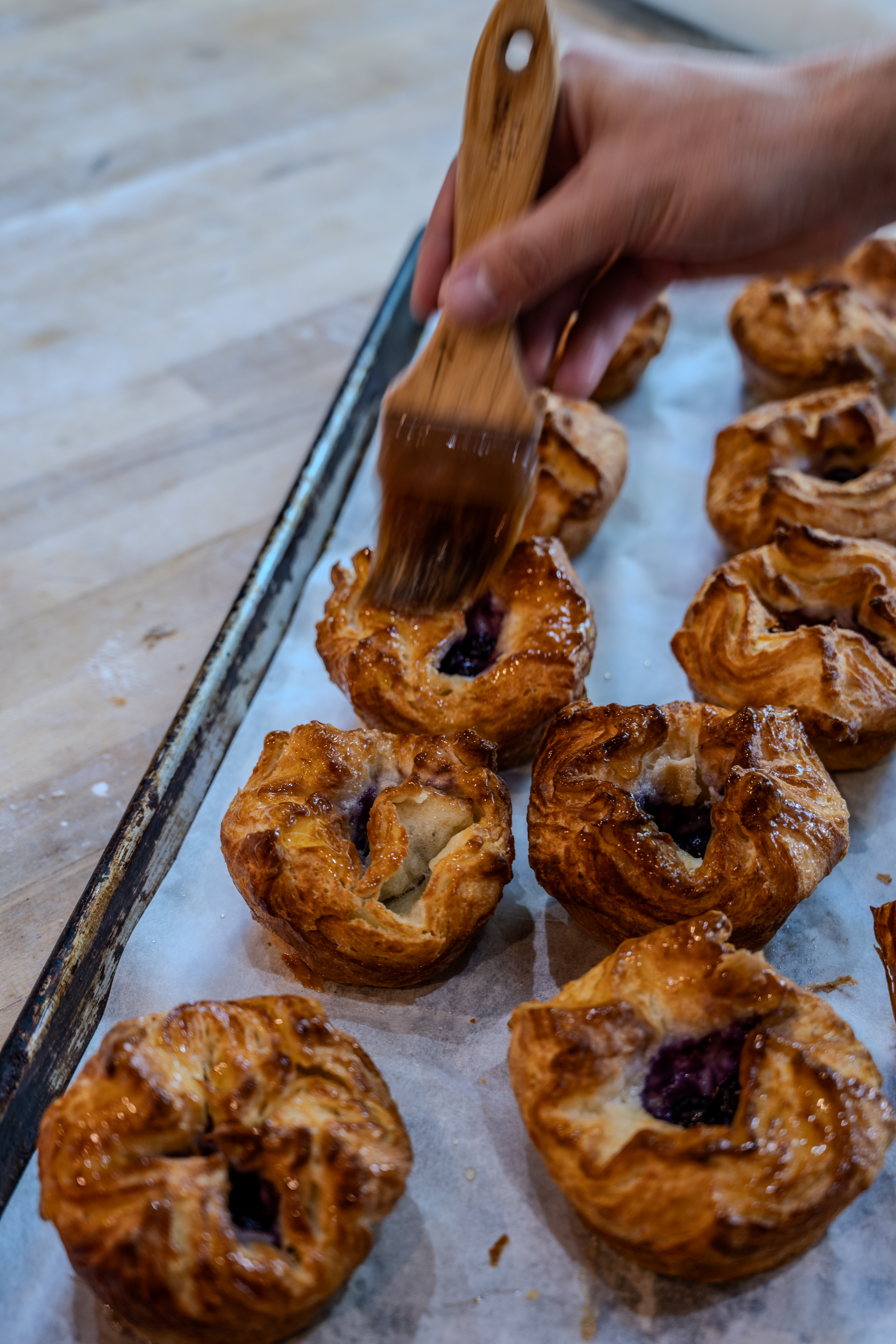 Brushing glaze over fresh-baked pastries at Montelimar Bread Co.
